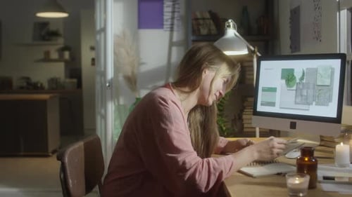 Woman Works at Desk with Computer and Notebook