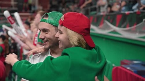 Nice couple cuddle sport stands arena. Loving people date. Happy romantic lovers