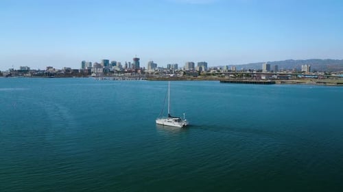 Ein einsames Segelboot driftet an einem sonnigen Tag im Wind in einer wunderschönen Bucht.