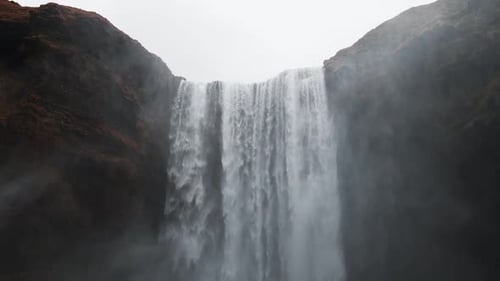 Majestic Waterfall Plunging from Cliffside on Overcast Day
