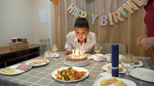 Boy Celebrates Birthday at Festively Decorated Table