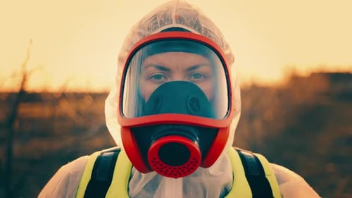 Person in Hazmat Suit and Gas Mask at Sunset