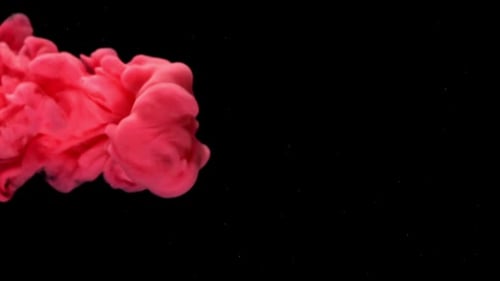 Red ink swirling in water on black background