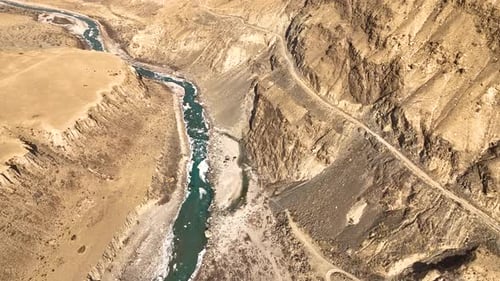 Aerial view of a turquoise river in a massive arid mountain canyon