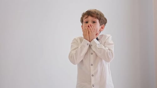 Retrato de cerca de un niño sorprendido tocándose la cara: expresiones infantiles y concepto de personas