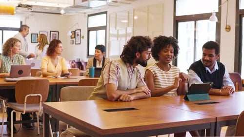 Diverse Business People Discussing Work Using a Tablet in a Coworking Office Space