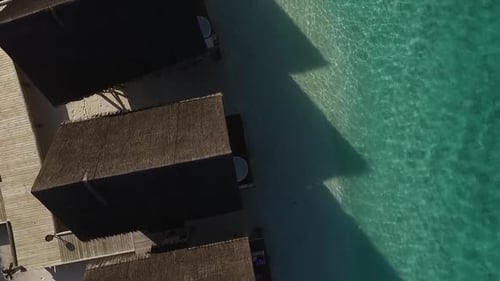 Drone atirou acima da água, vilas, telhados de spa em um resort nas Maldivas. água turquesa. Full HD