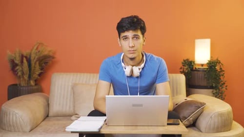 Young Man Typing on Laptop at Home