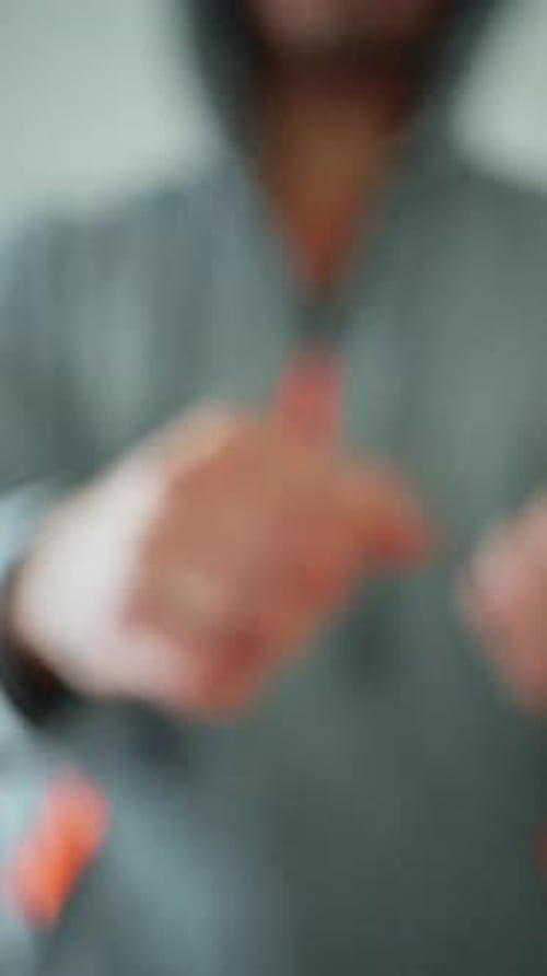 Man with Clenched Fist Reaches Toward Camera
