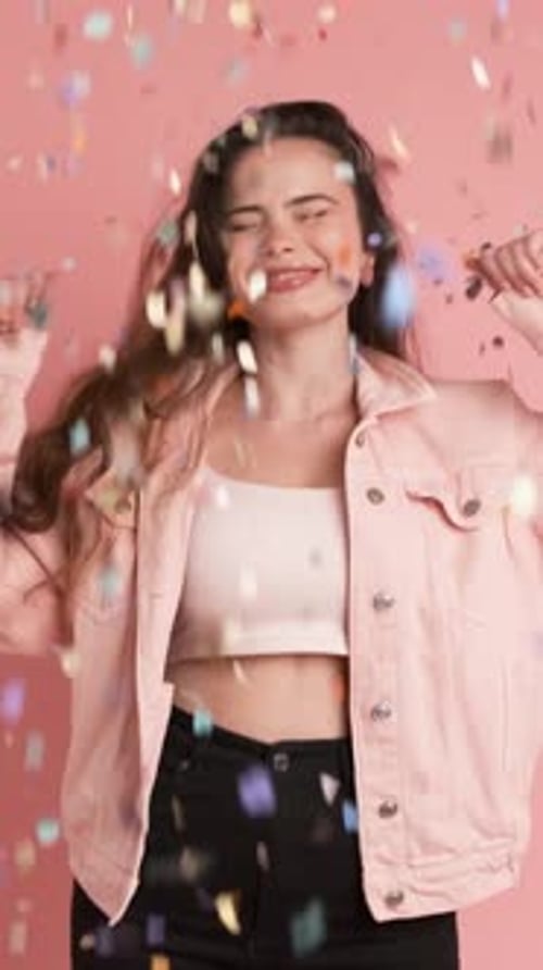 Young Woman Celebrates with Confetti in Studio