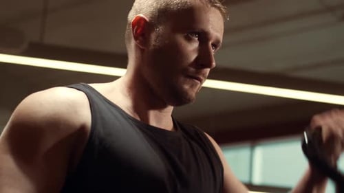 Sportlicher gutaussehender männlicher Sportler, der im Fitnessstudio mit Hanteln arbeitet Starker und gesunder Bodybuilder