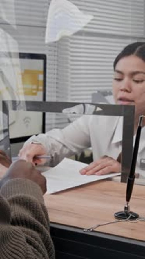 Bank Teller Assists Senior Man Signing Document