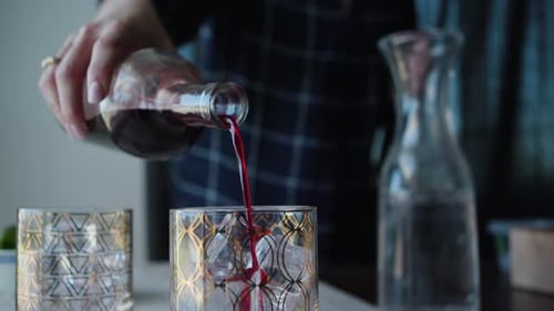 Gießen Sie roten Schnaps in ein Cocktailglas für die Aufnahme von Lebensmitteln. Aufgenommen auf einer Canon C200 in 4K
.