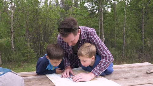 Father and Sons Navigating with a Map in Nature