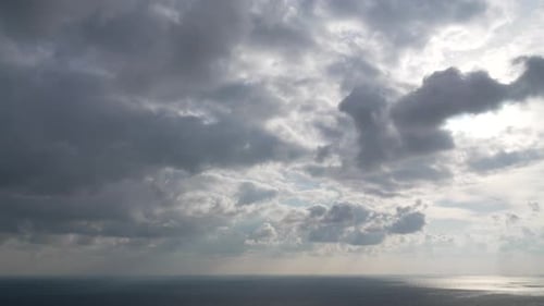 Timelapse : cumulus moelleux se déplaçant dans un ciel doré brillant au coucher du soleil au-dessus de la mer, nature aérienne abstraite
