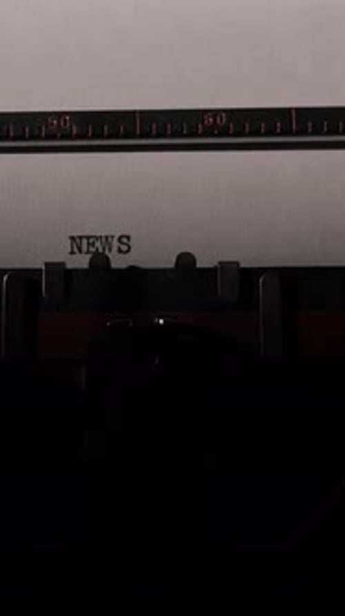 Typewriter types word News on blank white paper