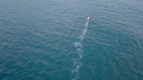 Aerial footage of High speed wind surfer riding the mediterranean waves
