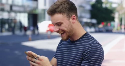 4k video footage of a handsome young man sending text messages while out in the city