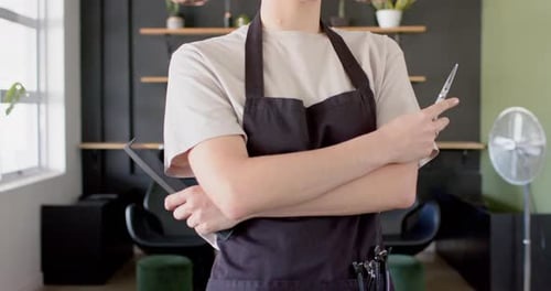 Hairdresser with Scissors and Comb Standing in Salon