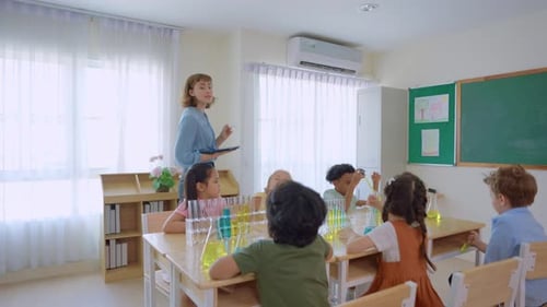 Adorable student learn with teacher in classroom at elementary school.