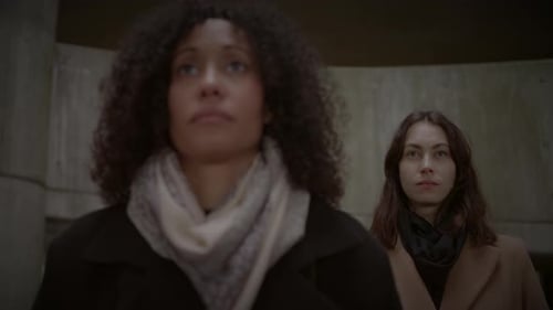 Lifestyle Portrait of Two Young Women Watching Tower Building Together