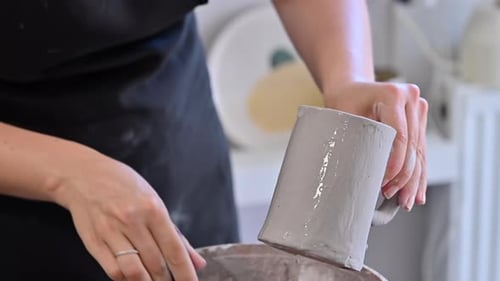 Woman painting a cup at pottery workshop