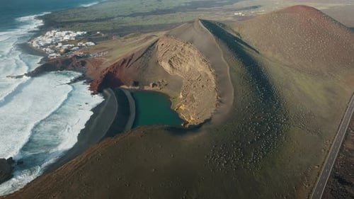 Vue aérienne par drone du Lago Verde, Green Lagoon, à Lanzarote, Espagne, avec des falaises volcaniques, noir