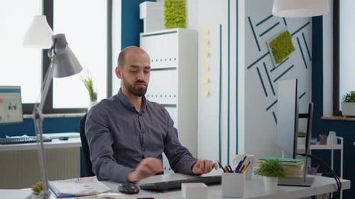 Adult Man Working at Computer in Modern Office