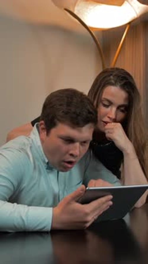 Couple Looking at Tablet Indoors Together