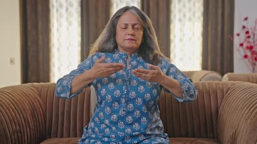 Woman Meditating Peacefully in Living Room on Couch