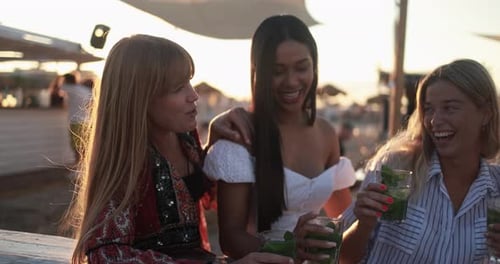 Happy multiracial girls having fun drinking mojitos at beach party outdoor