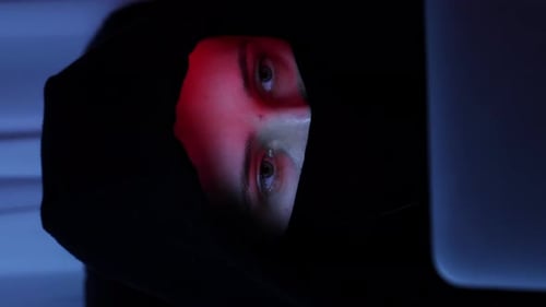 Female face looking at laptop screen. Close up of hacker face