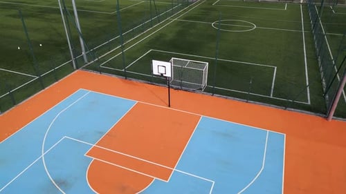 Aerial View of Outdoor Basketball and Soccer Courts with Vibrant Blue Orange and Green Colors The