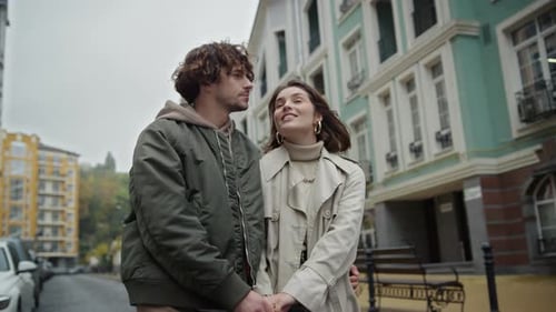 Happy Couple Walking Together Along City Street in Morning. Affectionate Man Holding