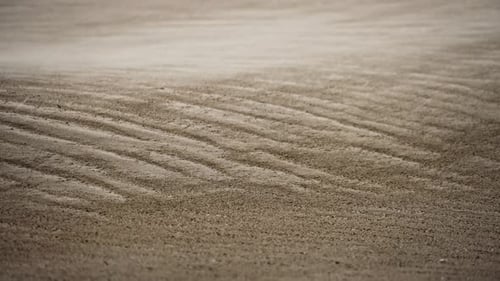 Gale-force winds blowing sand over beach during coastal storm