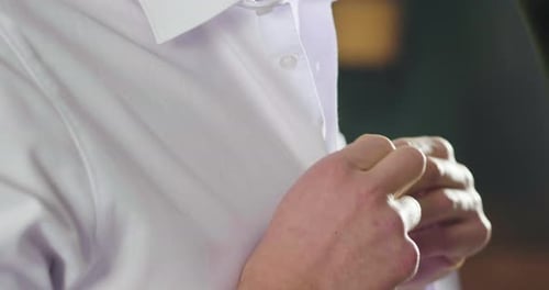 Nahaufnahme Ein gutaussehender Mann in seinem Loft kleidet sein sexy weißes Hemd sexy an und schaut in sein Zimmer