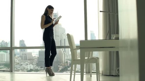 Businesswoman uses tablet in city apartment