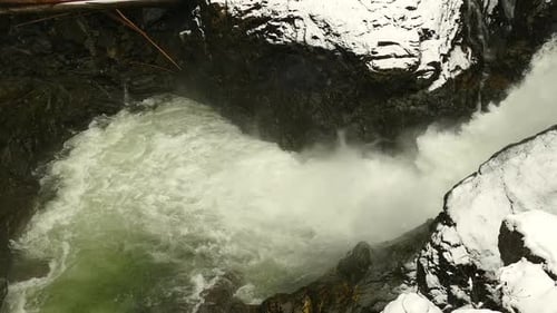 Rushing Waterfall in Snowy Winter Mountain Gorge