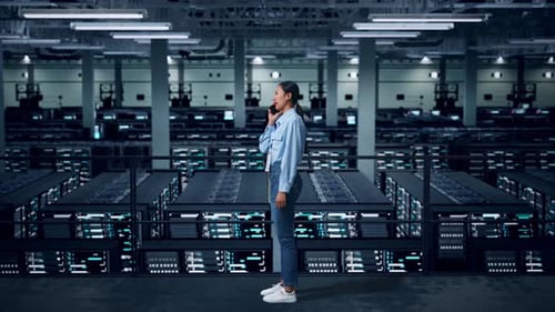 Side View Of Full Body Asian Business Woman Talking On Mobile Phone In Data Center
