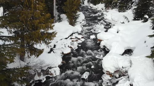 Water Running Down Into Mountain Forest During Winter Season. - aerial