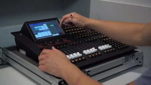Man Adjusting Lighting Mixer Pressing Buttons and Using Stylus on Touch Screen