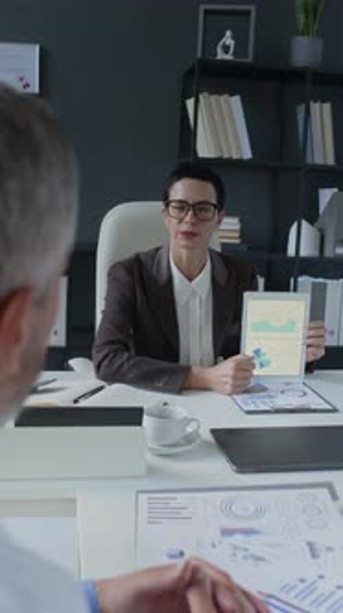 Clinic Director and Doctor Discussing Medical Reports in Office