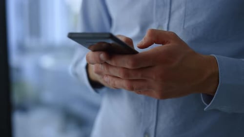 Businessman typing message on smartphone communication app close up slow motion
