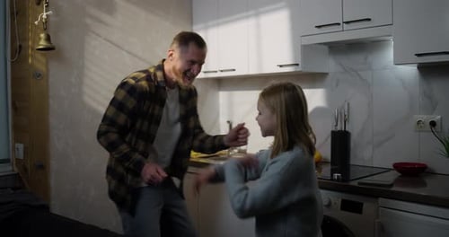 Father and Child Play Hand Game in Kitchen