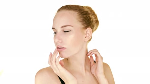 Elegant Woman Massaging Her Face Against White Background