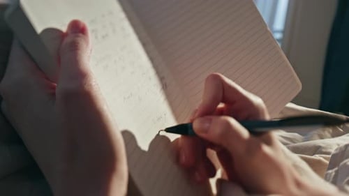 Female Hands Writing Diary in Sunlight Closeup Woman Making Notes in Morning