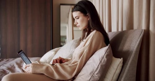 Young Woman Using Laptop While Relaxing in Bed