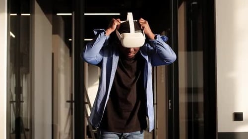 Young Adult Puts on VR Headset in Office