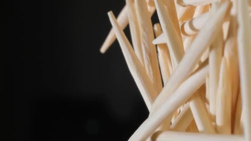 Cure-dents en bambou sur fond sombre, bâtonnets en bois pour le nettoyage des dents, vidéo verticale