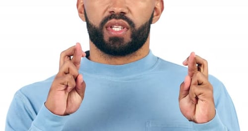 Anxiety, hands and man with fingers crossed in studio for hope, good luck